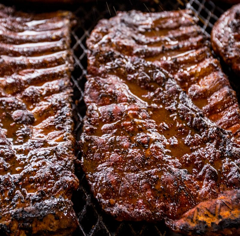 Several racks of Rodney Scott's pork ribs on the smoker.