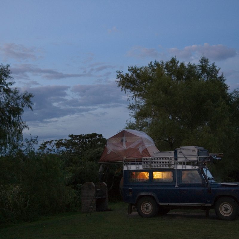 A vehicle with a rooftop tent at dusk.