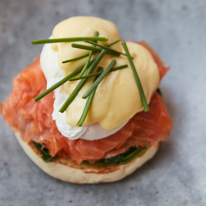 One smoked salmon eggs Benedict from queensyard on a gray blue plate.