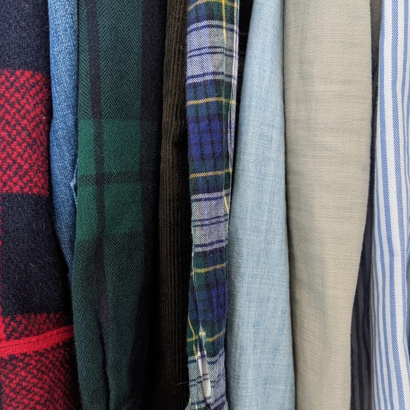 A view of the sleeves of hanging shirts.