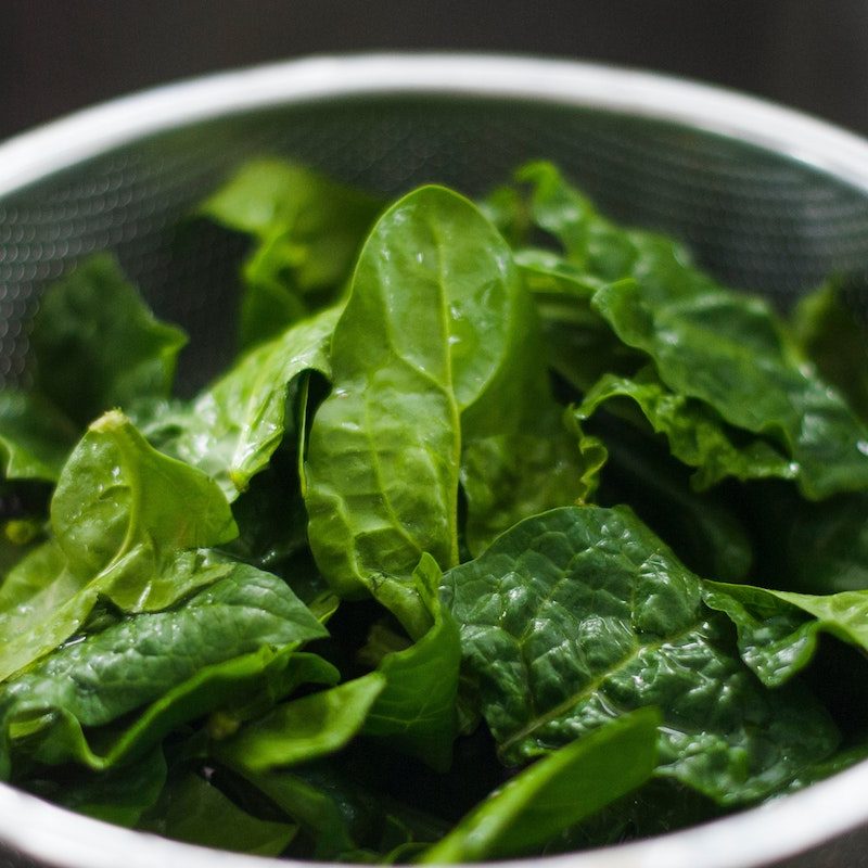 Green spinach leaves in a collander