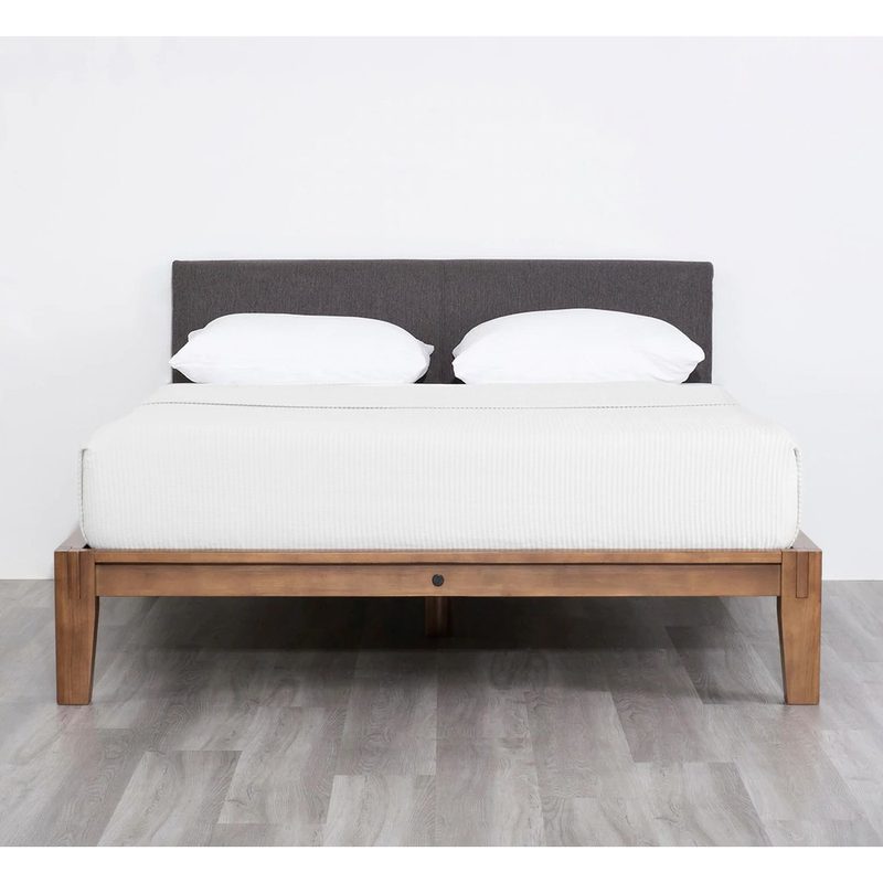 The Bed by Thuma features a black upholstered headboard and a wooden base.
