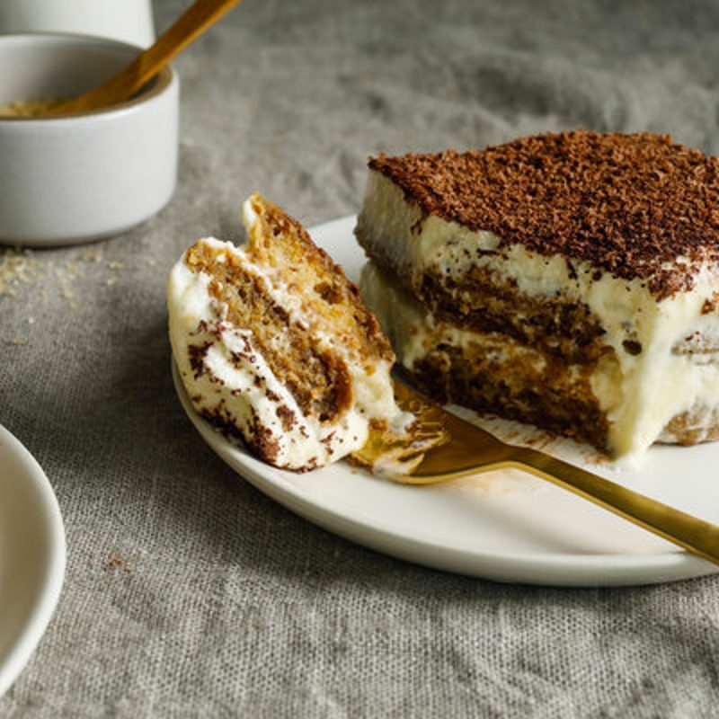 Tiramisu with a piece cut out using a fork.