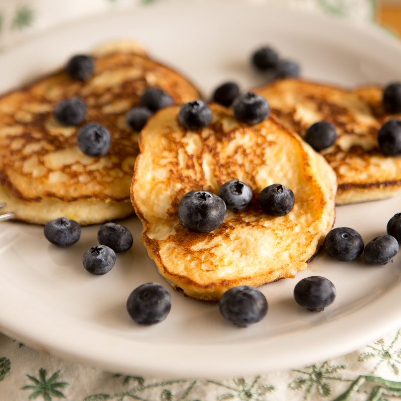 A plate of pancakes with blueberries on top.