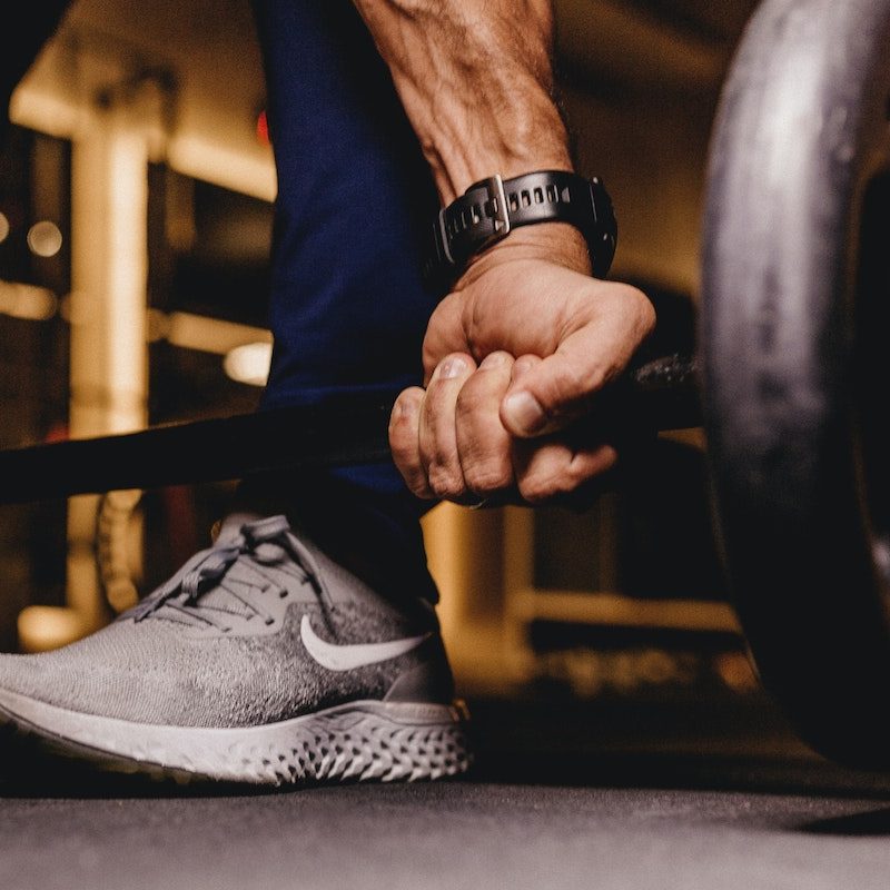 Man gripping a barbell to do a deadlift