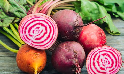 A close-up of fresh beets on wooden table.