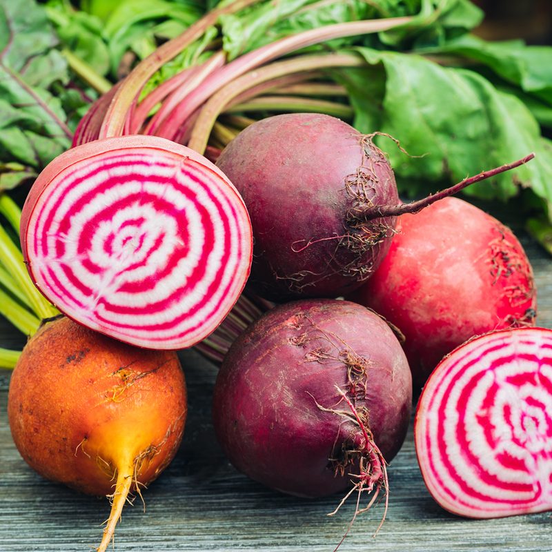 A close-up of fresh beets on wooden table.