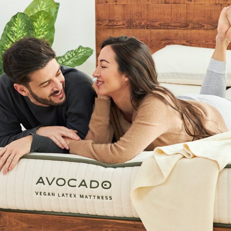 A couple lie on an Avocado Vegan Latex mattress.