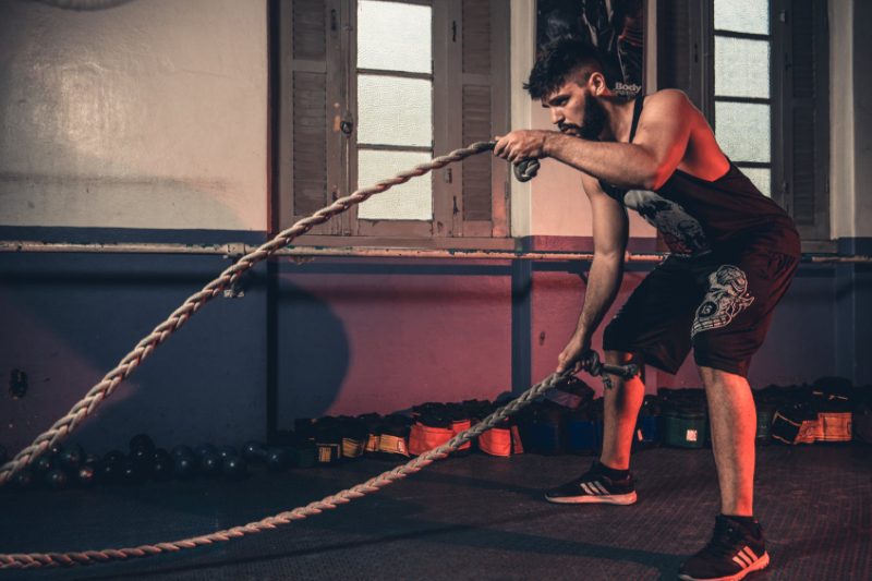 Man working out using battle ropes.