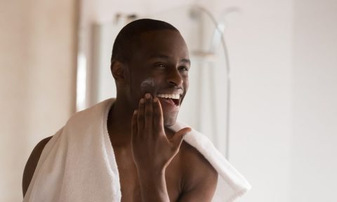 Man putting on face moisturizer.