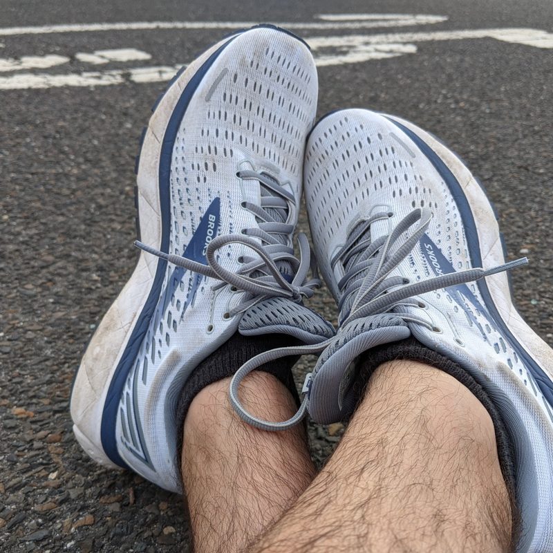 A used pair of Brooks Ghost 13 on the road.