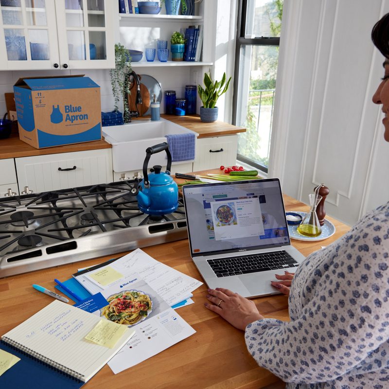 Woman busy working to prepare Blue Apron meal.