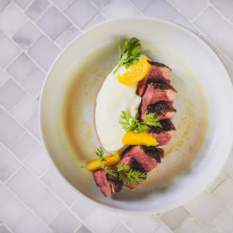 Chanson Le Salon duck a l'orange on white plate.