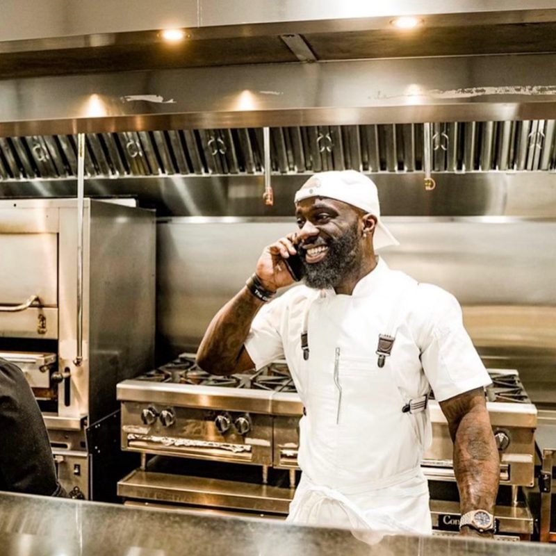 Chef Tobias Dorzon on cell in kitchen.
