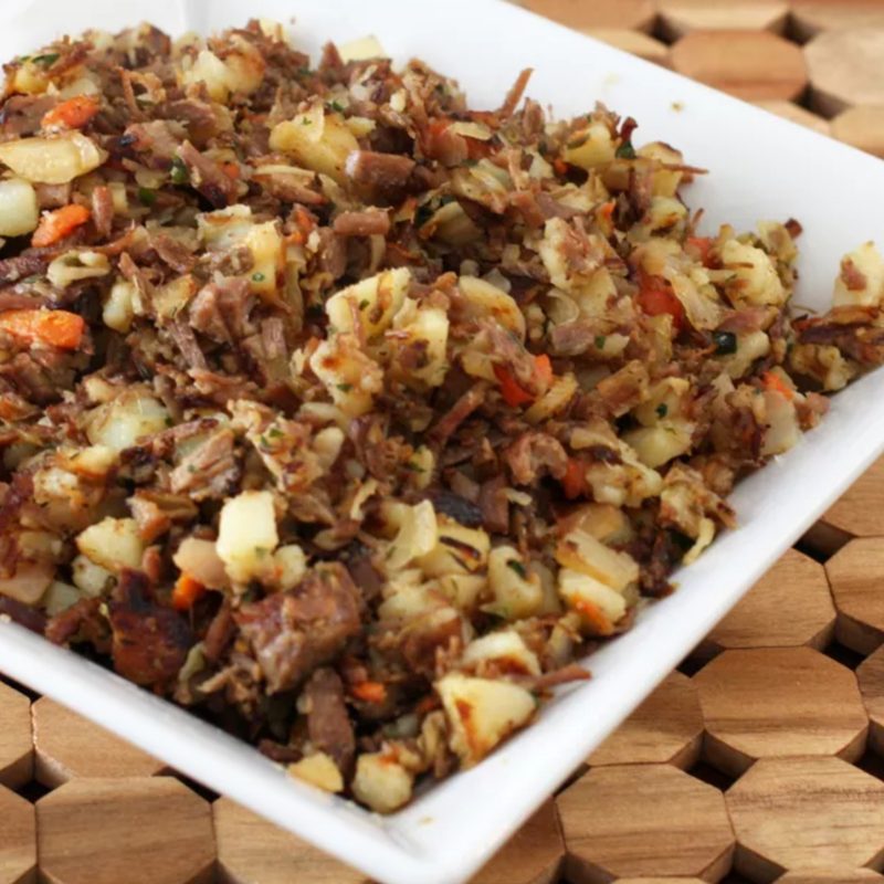 Corned beef hash in a square white dish.