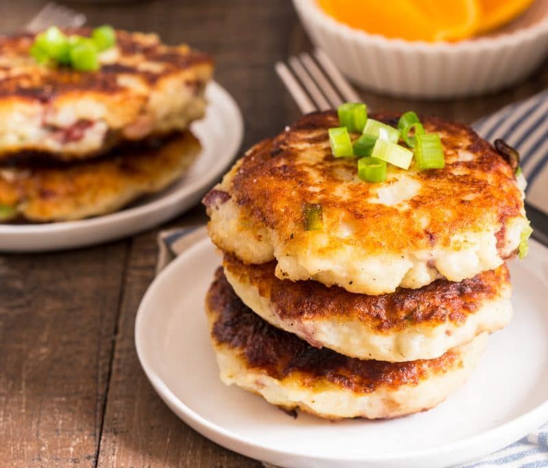 Stacks of corned beef patties in small white plates.