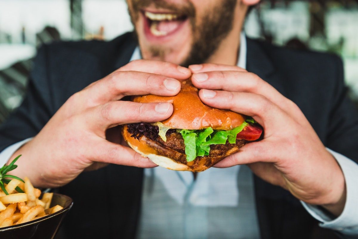 Man eating a big burger.