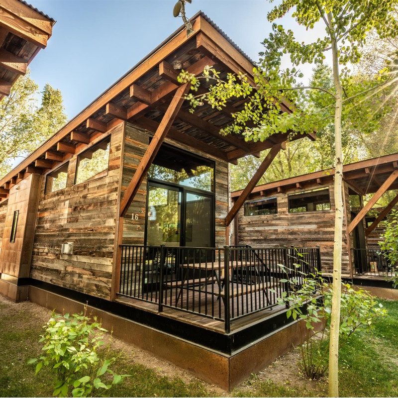 A Fireside Resort luxury cabin, sitting amidst green trees and tucked in next to the Teton Mountains.