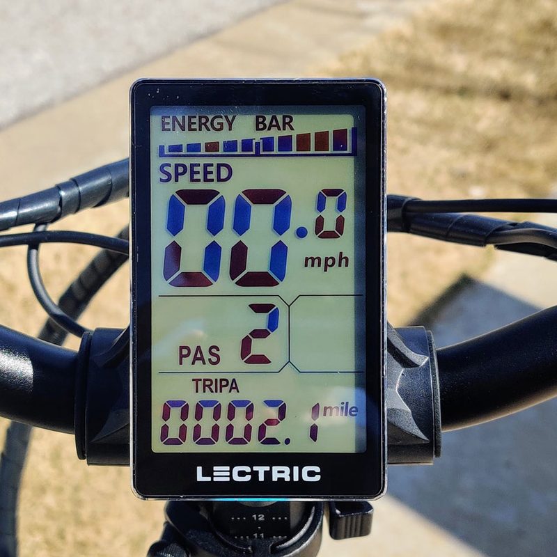 A heads-up LCD display on the handlebar of the Lectric XP 2.0 Black electric bike.