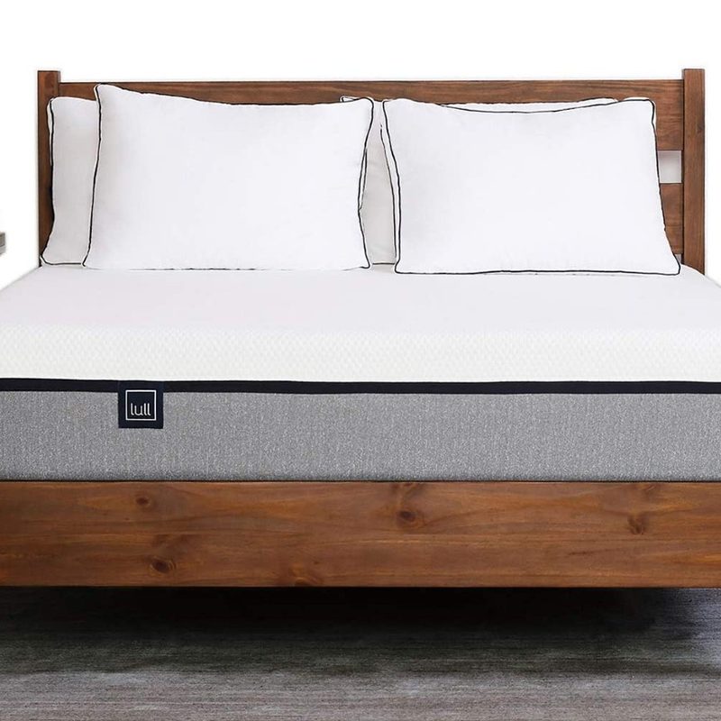 The Lull mattress placed on a dark wooden bed frame.
