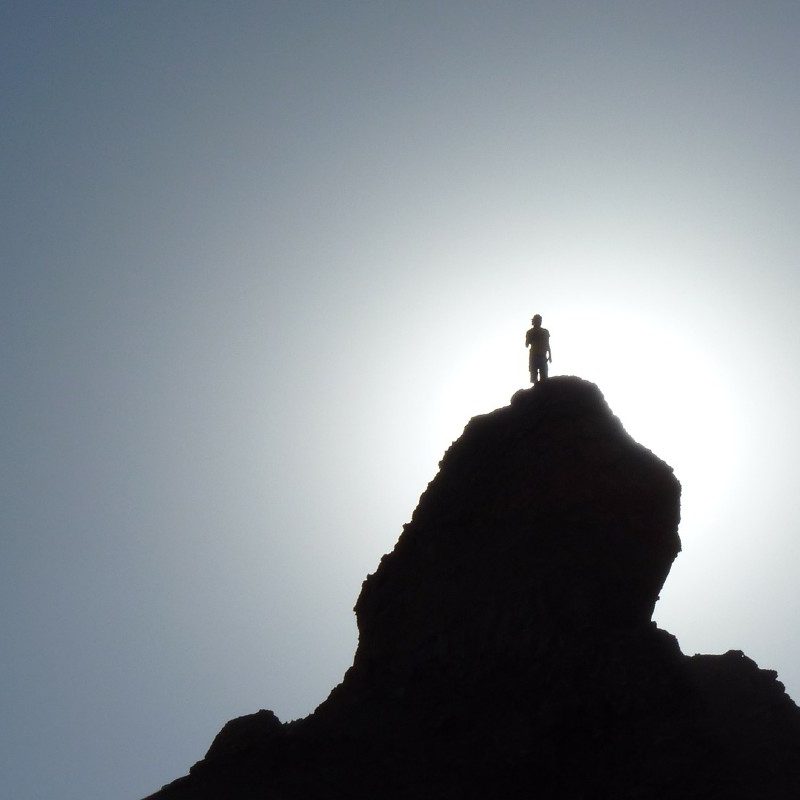 A silhouette of a man on a mountaintop.