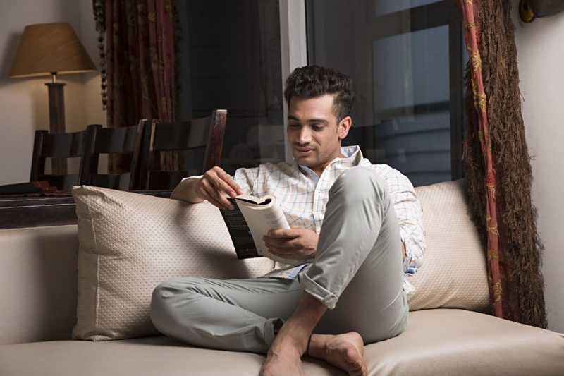 A man reads a book at home.