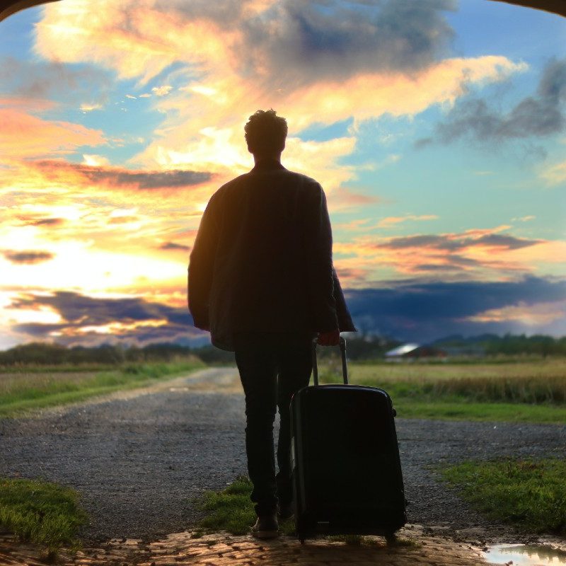 A man traveling with a suitcase that's filled with the best travel gear because he read this list.