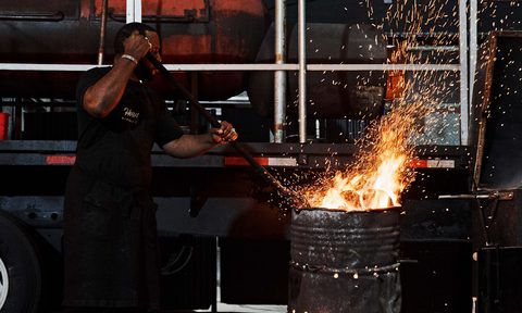 Pitmaster Matt Horn stoking a fire for bbq.