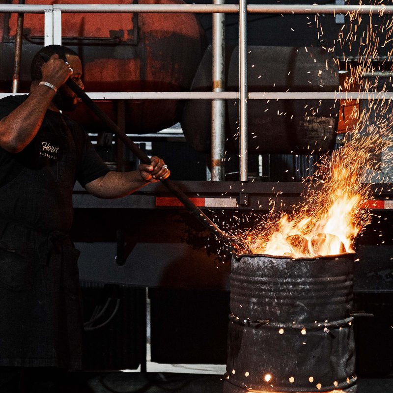 Pitmaster Matt Horn stoking a fire for bbq.