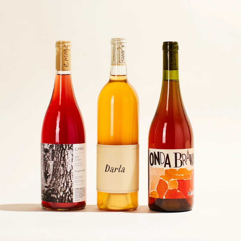 Three bottles of wine on flesh-colored background.