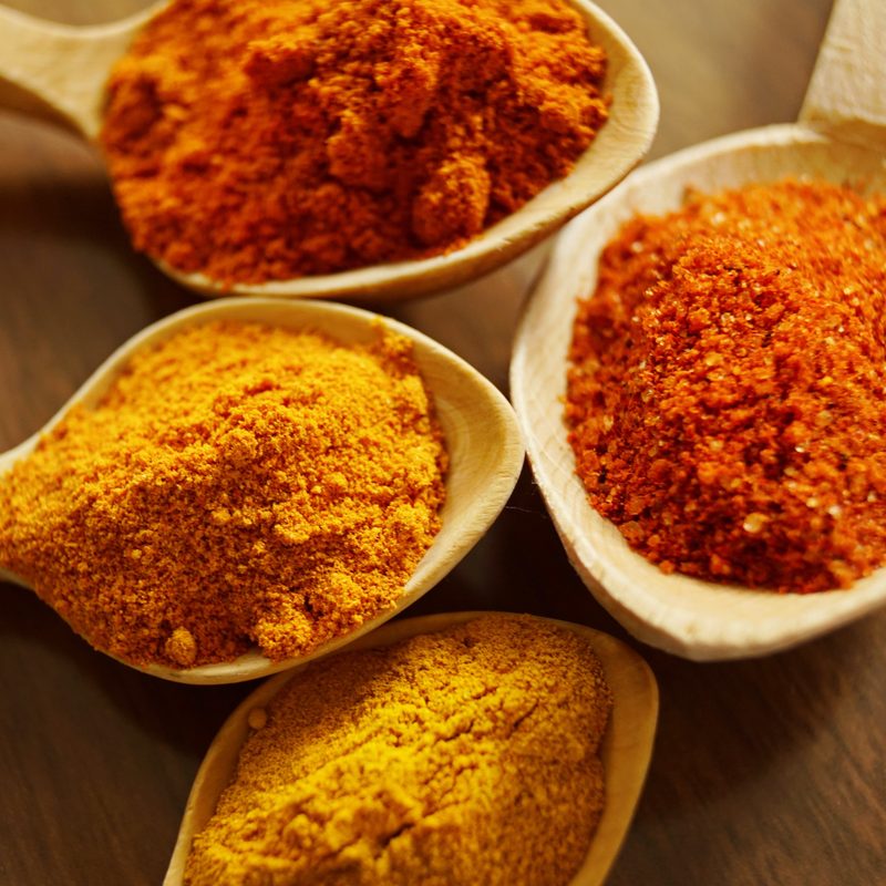 Four spoons with ground spices