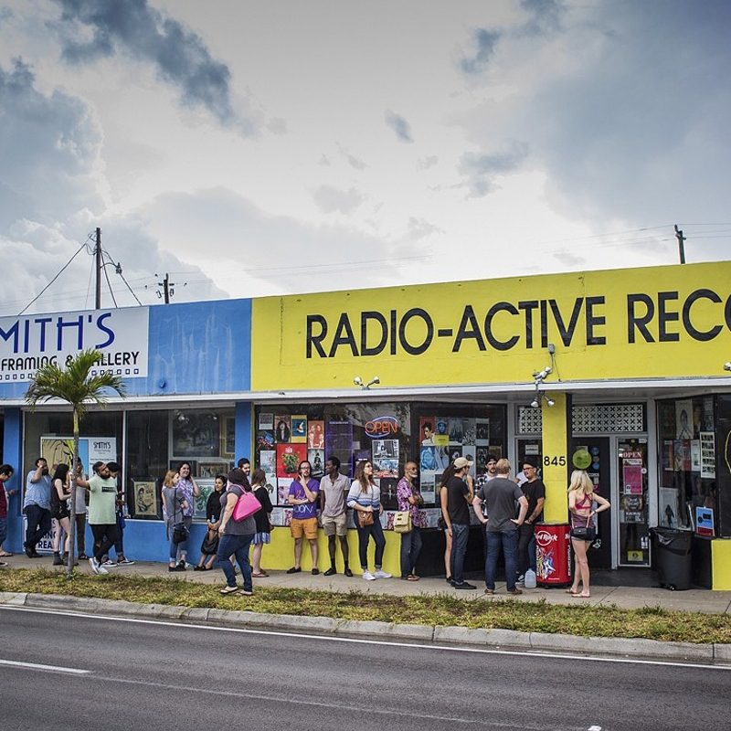 A crowd of people standing outside Radio-Active Records.