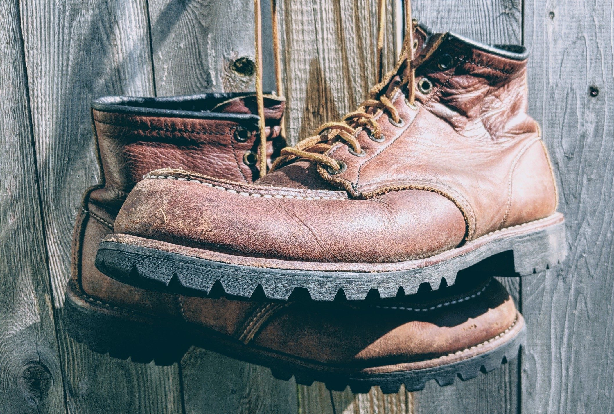 Worn in Redwing Moc Toe Boots hanging by their laces.