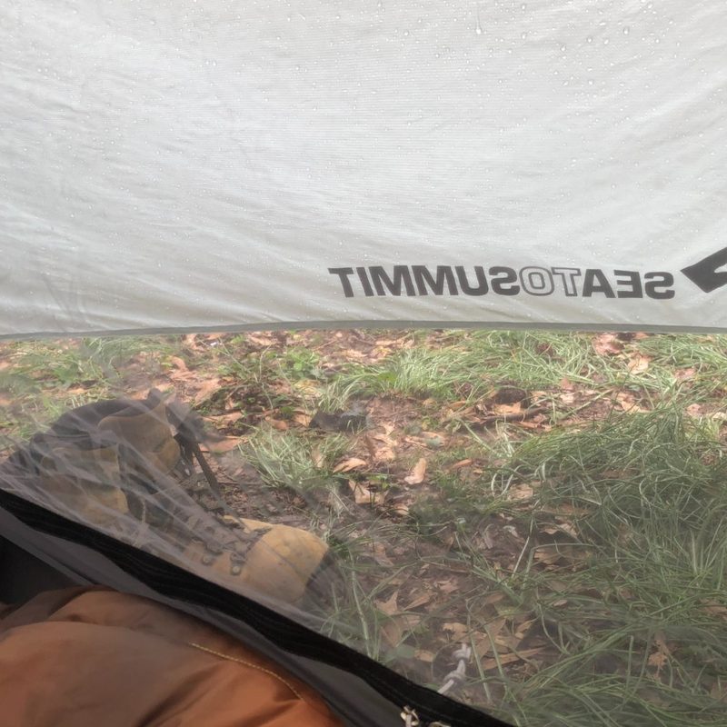 Vestibule view of a one-person tent in the rain.