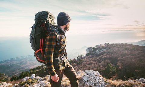 Mountain hiker with a large backpack looking into the distance.