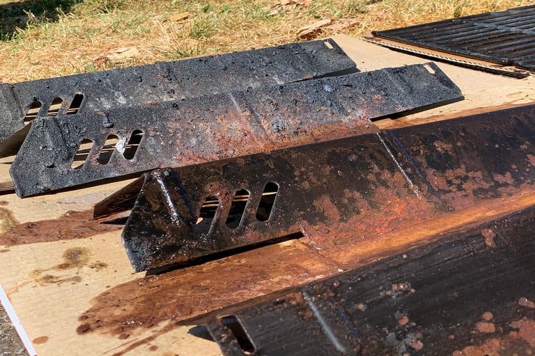 A gas grills internal components removed for cleaning