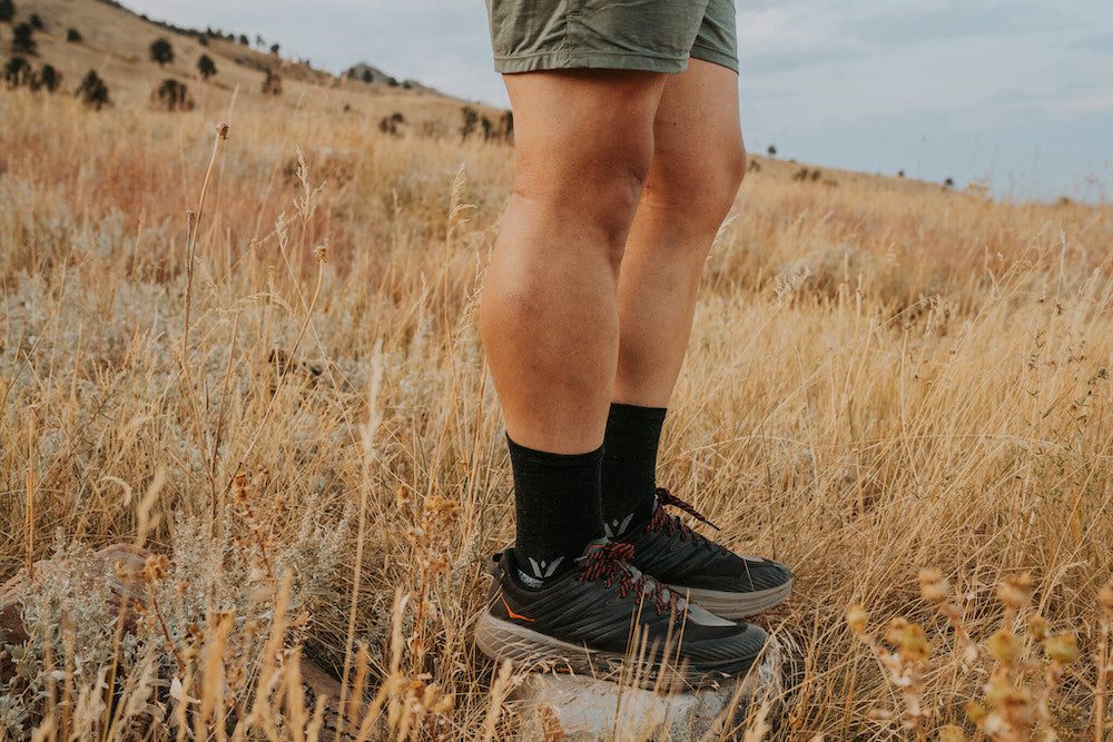 Man wearing swiftwick flite xt trail socks in a field.