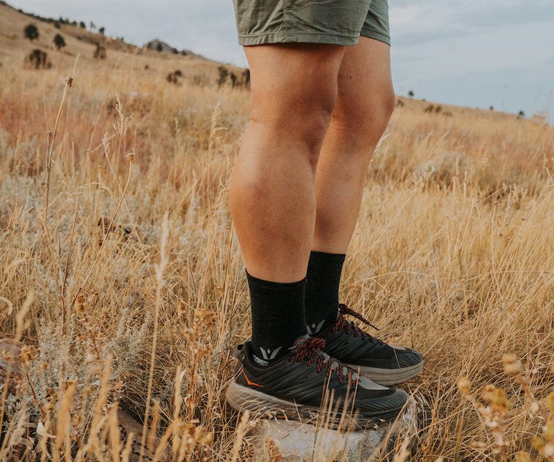 Man wearing swiftwick flite xt socks in a field.