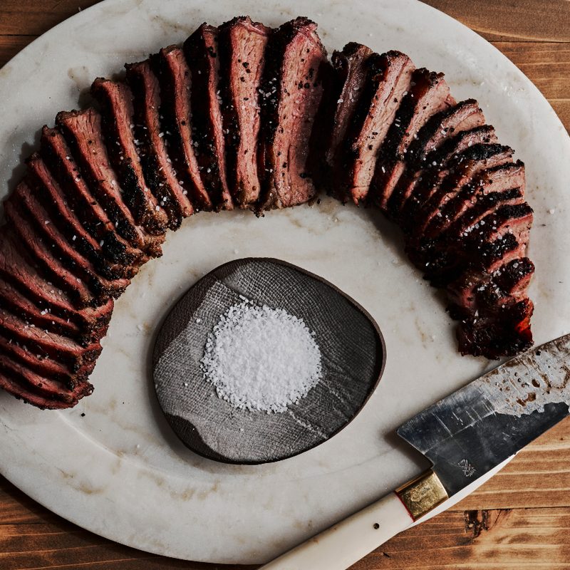 Horn BBQ Smoked Tri-Tip on a white plate with salt and knife.