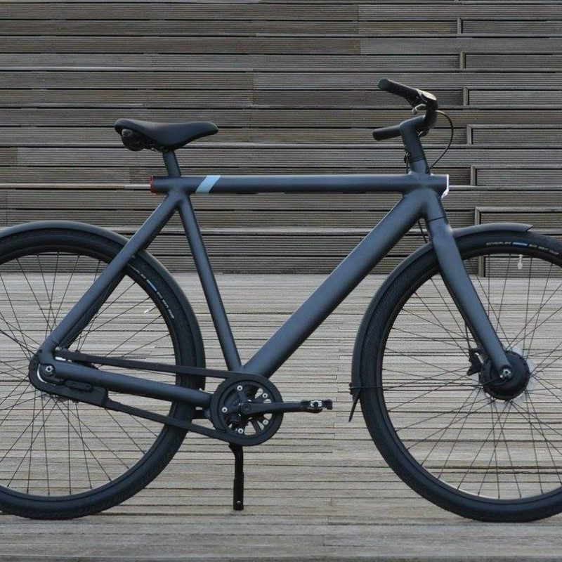 The VanMoof S3 ebike standing against some stairs.