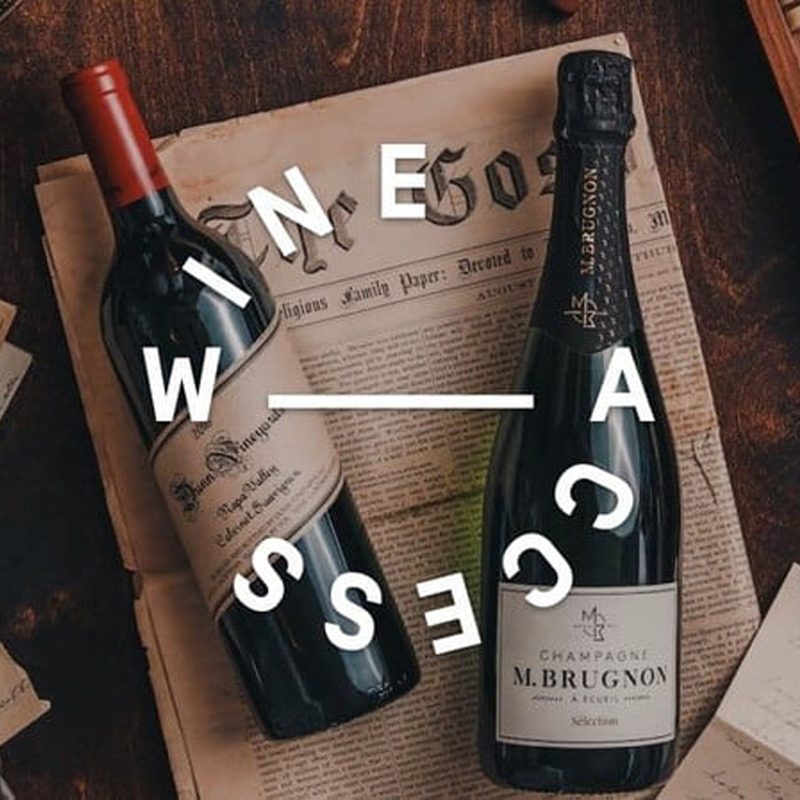 Vintage letters and two bottles of wine on vintage newspaper with the text “Wine Access” in white font encircling a white straight line at the center.