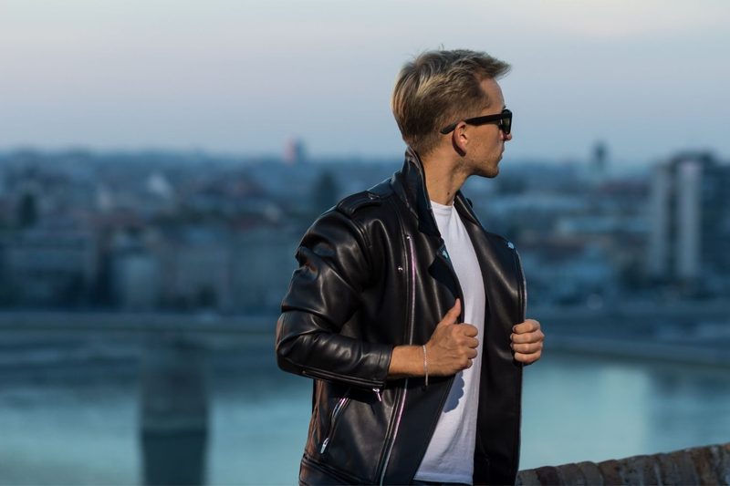 Man in leather jacket with cityscape in background
