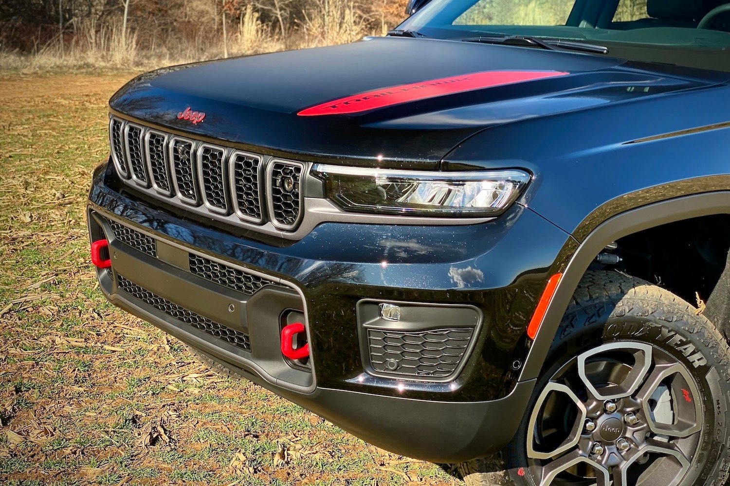 Front end of 2022 Jeep Grand Cherokee Trailhawk in a grassy field.