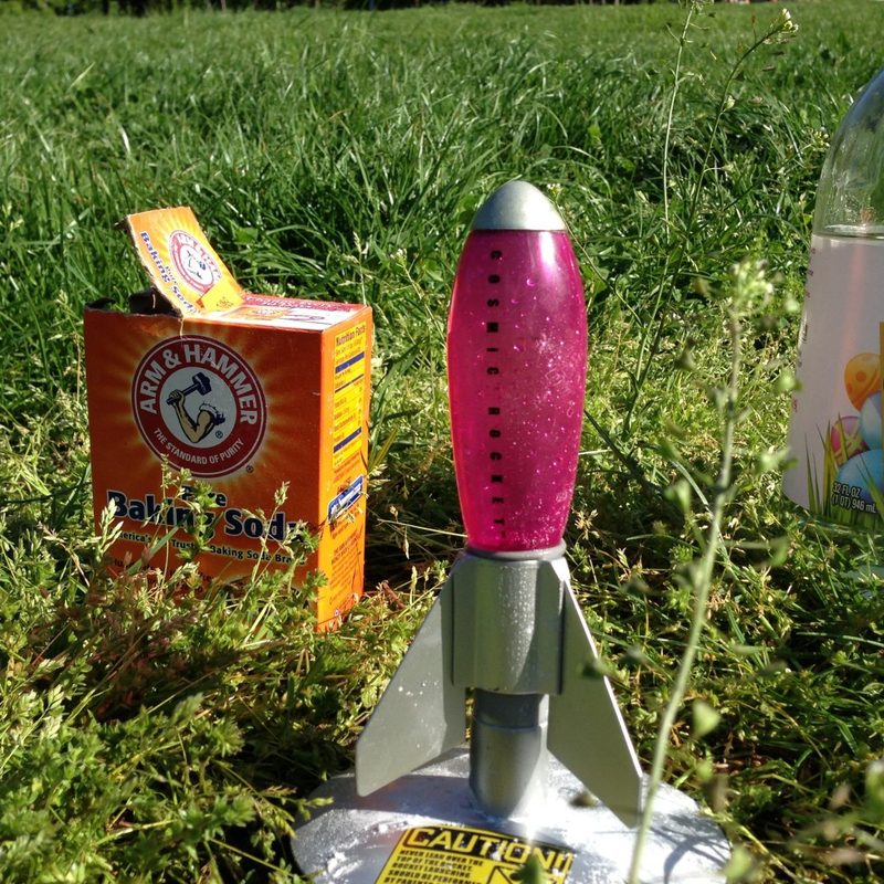 A homemade rocket made with baking soda and vinegar on the grass.