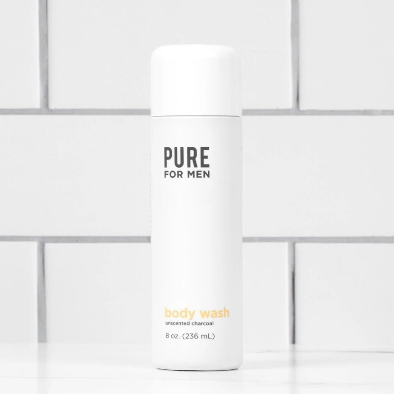 A bottle of Pure for Men Charcoal Body Wash in a bathroom.