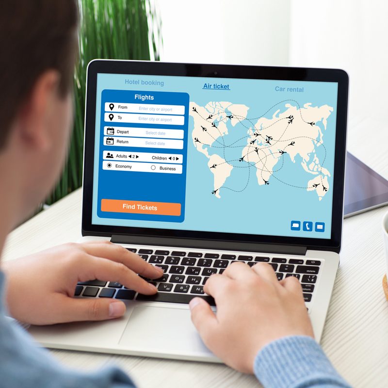 A man using his laptop to book a flight