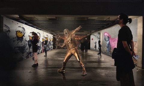 'Man with Flowers' centers this view of the new 'Banksyland' exhibit in Portland, traveling across the United States.