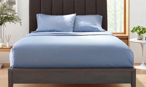 A set of slate blue Clean Design Home x Martex bed sheets on a bed.