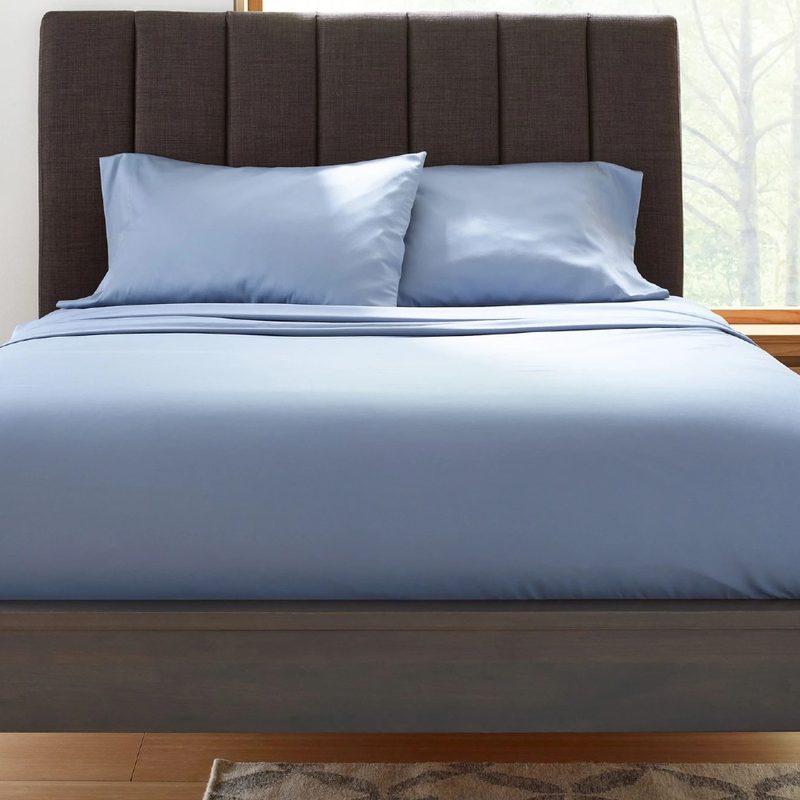 A set of slate blue Clean Design Home x Martex bed sheets on a bed.