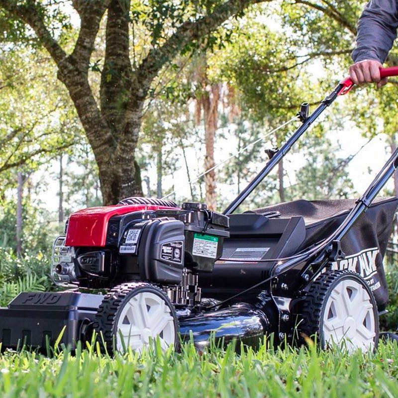 A man mows his lawn with the Black Max self-propelled lawn mower.